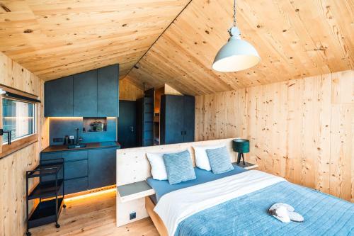 een slaapkamer met een bed in een houten kamer bij Himmelchalet - Alpencamping Nenzing in Nenzing