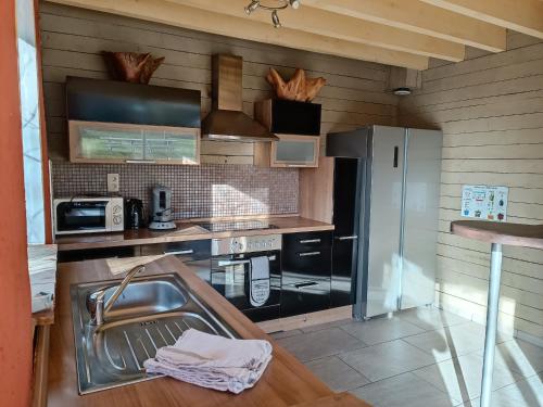 a kitchen with a sink and a refrigerator at La Ligule in Mignault