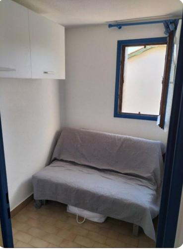 une petite chambre avec un lit et une fenêtre dans l'établissement Studio cabine Grau D Agde résidence avec piscine, au Grau-dʼAgde