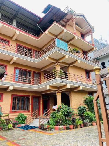 un gran edificio con balcones y plantas en sauraha alley inn en Chitwan