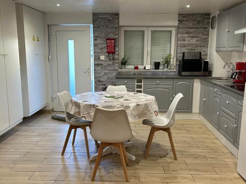 a kitchen with a table and chairs in a kitchen at Chez nathalie in Habay-la-Neuve
