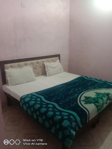 Un dormitorio con una cama con una manta verde. en HOTEL BLUE ICE, en Chandīgarh