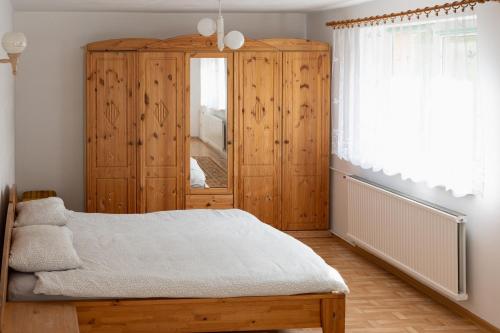una camera con letto e armadio in legno di Dom & SPA nad Rzeką a Dębnica Kaszubska