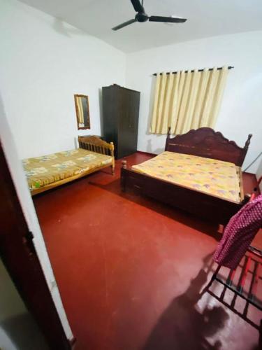 een kamer met 2 bedden en een plafond bij SL Amoree house in Matara