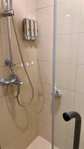 a shower with a glass door in a bathroom at 38 Park Avenue right in the heart of IT Park Cebu, 55 inches TV, wifi in Tabok