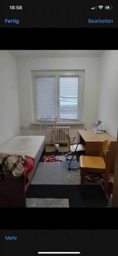Schlafzimmer mit einem Bett, einem Schreibtisch und einem Tisch in der Unterkunft Ouabou in Greifswald