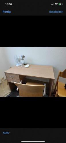 einen Holztisch mit Stühlen und einen Schreibtisch in der Unterkunft Ouabou in Greifswald