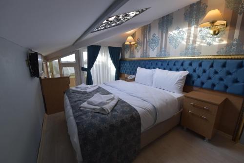 a bedroom with a large bed with a blue head board at GOLDEN PALACE SEA ViEW in Istanbul