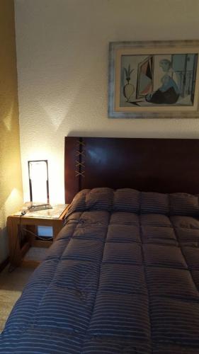 a bedroom with a bed and a desk with a lamp at El Olvido in La Paloma