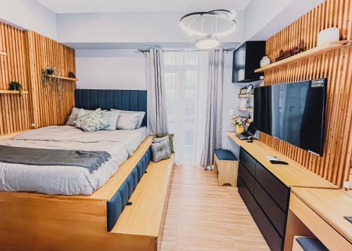 a bedroom with a bed and a flat screen tv at Saint Honore Studio Retreat with Amenities in Iloilo City