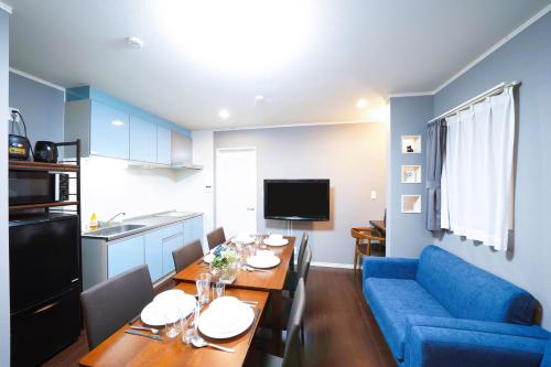 a living room with a table and a blue couch at 浅草ザ アパートメント Asakusa The Apartment in Tokyo