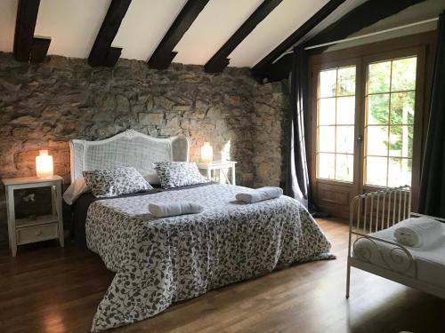 a bedroom with a bed and a stone wall at Relax, montaña, paz in Errezil