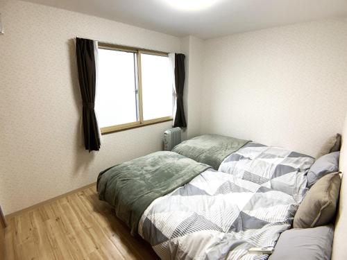 旭川的住宿－Shinsanjo Building - Vacation STAY 15855，一间卧室设有一张床和一个窗口