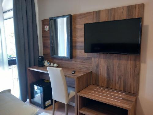 Schlafzimmer mit einem Schreibtisch und einem TV an der Wand in der Unterkunft BRIXELLUM in Brescello