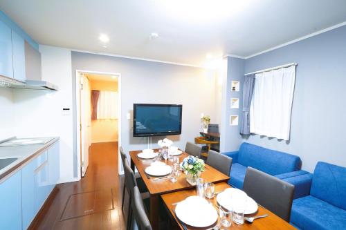 a living room with a table and a blue couch at 浅草ザ アパートメント Asakusa The Apartment in Tokyo