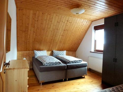 un sofá en una habitación con techo de madera en Ferienwohnung am Lehnberg, Familie Richter, en Neue Häuser