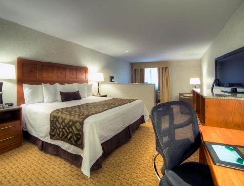 a hotel room with a bed and a flat screen tv at Moab Valley Inn in Moab