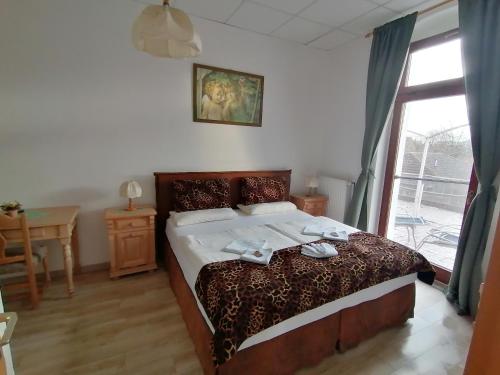 Schlafzimmer mit einem Bett, einem Tisch und einem Fenster in der Unterkunft Landhotel Storchenkrug in Rühstädt