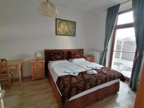 a bedroom with a bed and a table and a window at Landhotel Storchenkrug in Rühstädt