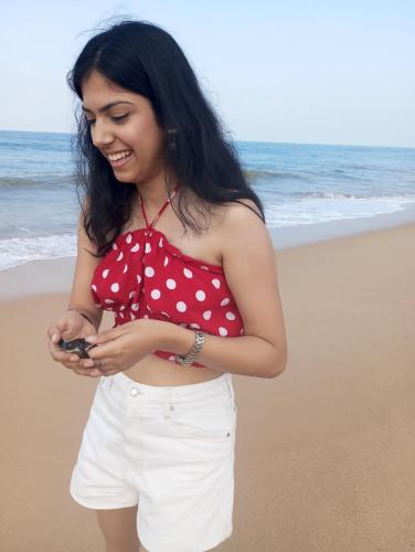 a woman standing on the beach looking at her cell phone at Nade Villas Ahungalla in Ahungalla
