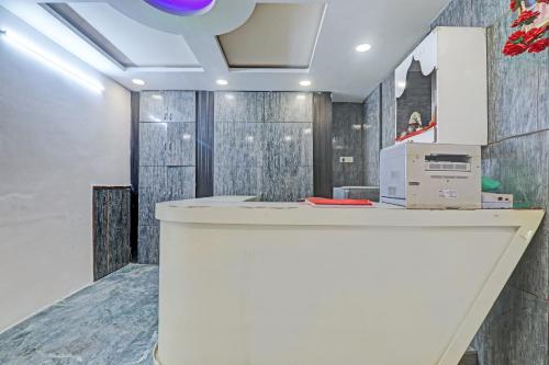 an office lobby with a white counter and wood walls at OYO Flagship The Relax Inn in Lucknow