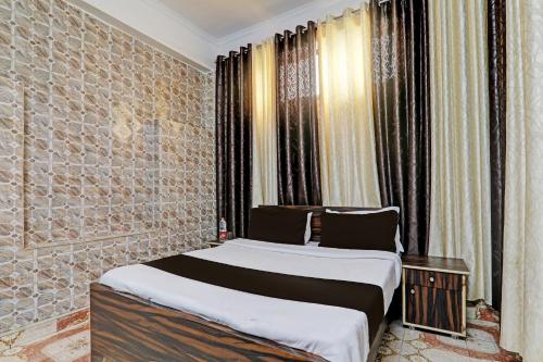 a bedroom with two beds in a room with windows at OYO Flagship The Relax Inn in Lucknow
