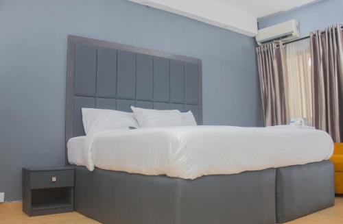 a bedroom with a large bed with a large headboard at MORADA HOTELS LTD in Lagos