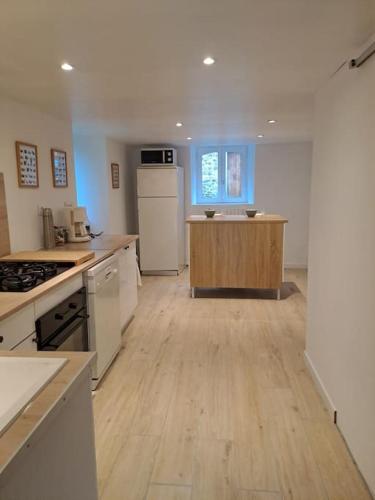 Il comprend une grande cuisine avec des appareils blancs et du parquet. dans l'établissement Belle maison au bord de l'eau, à Saint-Jean-sur-Mayenne
