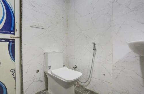 a white bathroom with a toilet and a sink at GAURA NITAI GUEST HOUSE in Dahmi