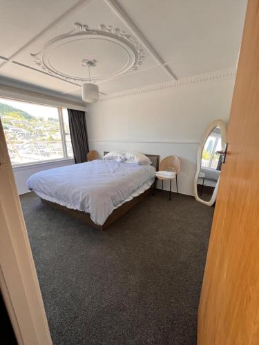 ein Schlafzimmer mit einem Bett und einem großen Fenster in der Unterkunft Moon House in Queenstown