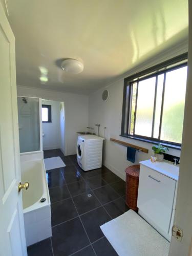 een badkamer met een wastafel en een magnetron in een kamer bij Somerby! in Albury