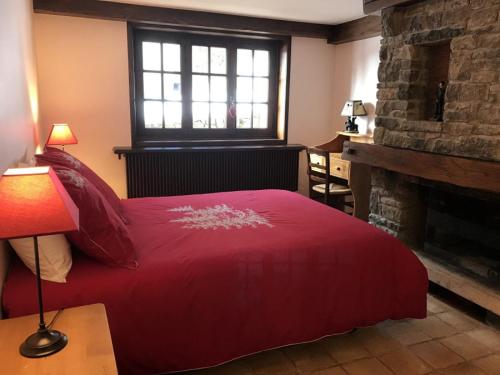 a bedroom with a red bed and a fireplace at Grangettes in Les Carroz d'Araches