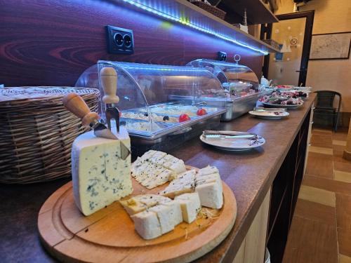 un buffet con formaggio e altri prodotti alimentari su un bancone di Pensiunea Mușatinii a Putna