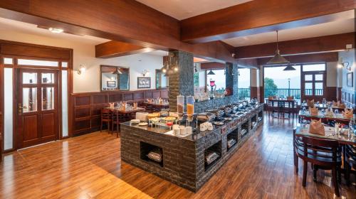 a restaurant with a fireplace in the middle of a room at Fort Munnar in Chinnakanal
