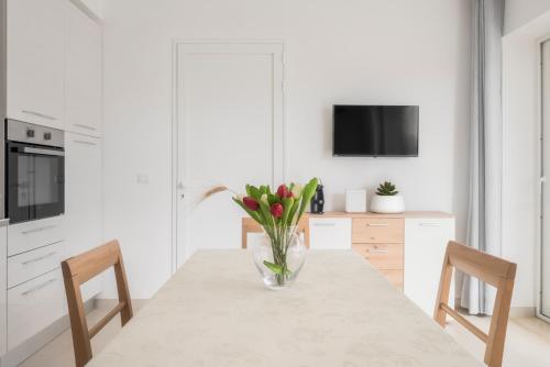 a kitchen with a table with a vase of flowers on it at DolceVitaSuites - Modern 3 Bdr Villa in S. Lorenzo in San Lorenzo