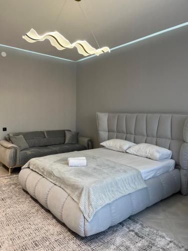 1 dormitorio con 1 cama grande y 1 sofá en ЖК Amir, en Almaty