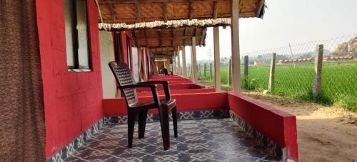 uma cadeira sentada no exterior de um edifício em Laughing Buddha hampi guest House em New Hampi