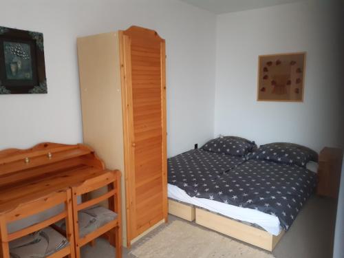 1 dormitorio pequeño con 1 cama y armario de madera en Balatonberényi Vendégház, en Balatonberény