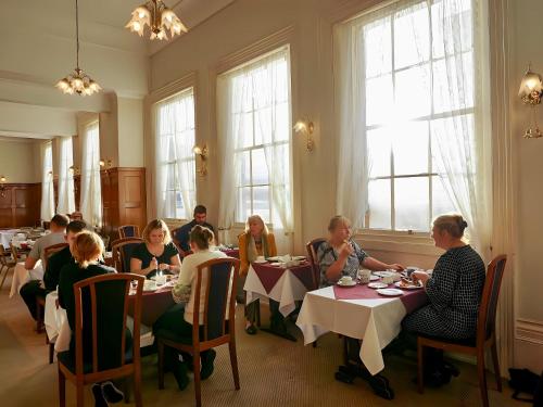 a group of people sitting at tables in a restaurant at The Star Hotel in Southampton