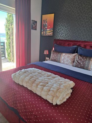 a bedroom with a large bed with a red bedspread at Villa Belissima Vista Mare in Selce