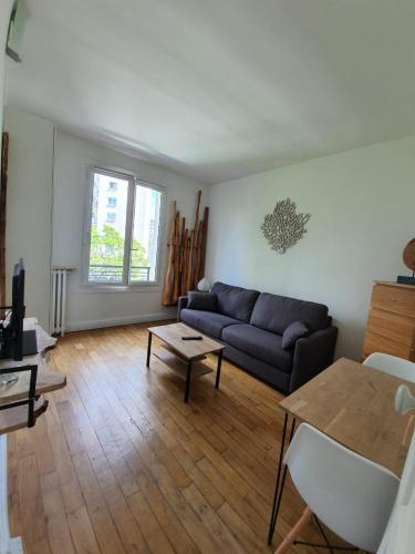 een woonkamer met een bank en een tafel bij Chambre privée dans magnifique appartement calme in Parijs