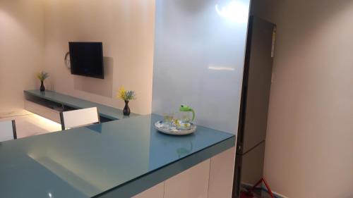 a kitchen with a blue counter top and a television at 'Savitham' City View flat in Trivandrum in Trivandrum