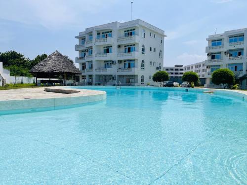 a large swimming pool in front of a building at Bharazah Luxury Apartment in Malindi