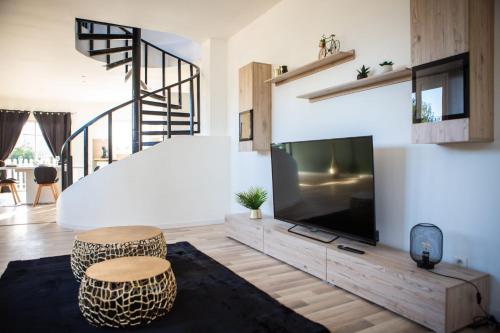 - un salon avec une grande télévision et deux tabourets dans l'établissement Maison Rénové Spacieuse Cosy Jardin 8 Pers, au Mans
