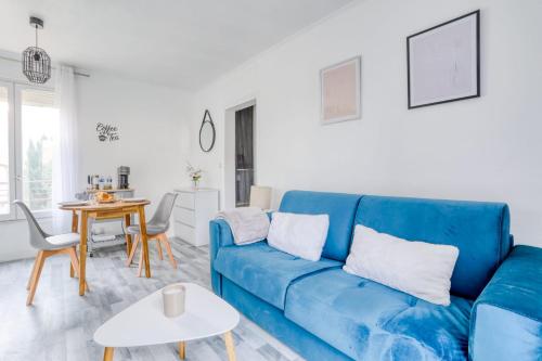 sala de estar con sofá azul y mesa en Magnifique Appart Cosy Rénové Gare 2 pers, en Gagny