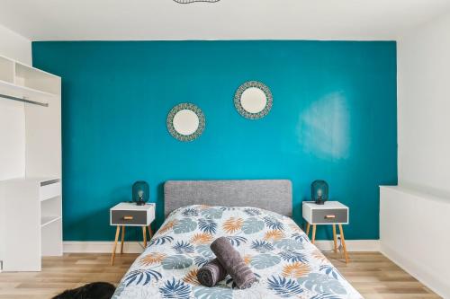 une chambre avec un mur bleu et un lit dans l'établissement Magnifique Appart centre ville rénové 2 pers, au Mans