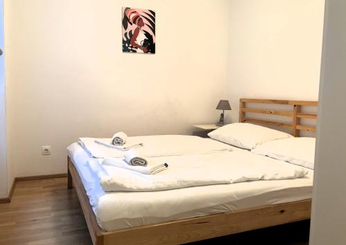 ウィーンにあるCasa Nostra - Ruhige Stadtwohnung mit Balkonのベッドルーム1室(白いシーツが備わるベッド2台付)
