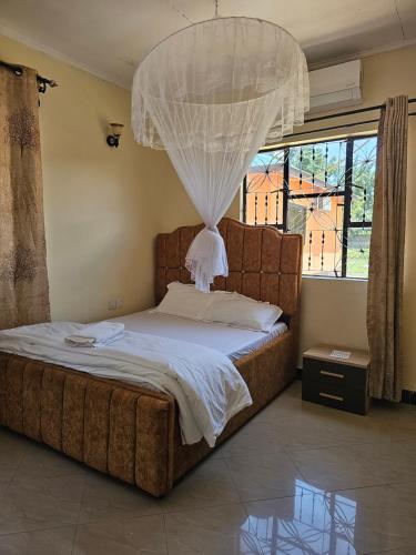 1 dormitorio con 1 cama con lámpara de araña encima en B-MORE COMFORT STAY en Boma la Ngombe
