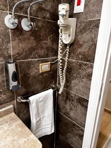 a bathroom with a hair dryer and a phone on a wall at Rentrific in Cairo