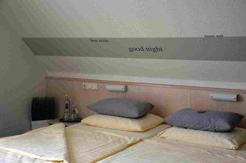 two beds in a room with words on the wall at Hotel Hamm in Weiterstadt